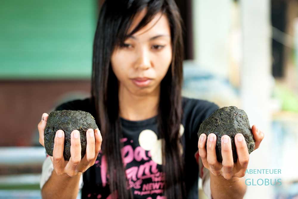 Eine Mitarbeiterin vom Elephant POOPOOPAPER Park wiegt Kugeln aus Elefantendung von je 500 Gramm.