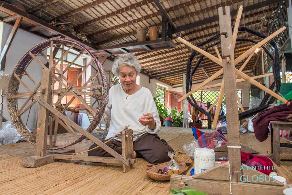 Eine Weberin im Thai Silk Village nahe Chiang Mai