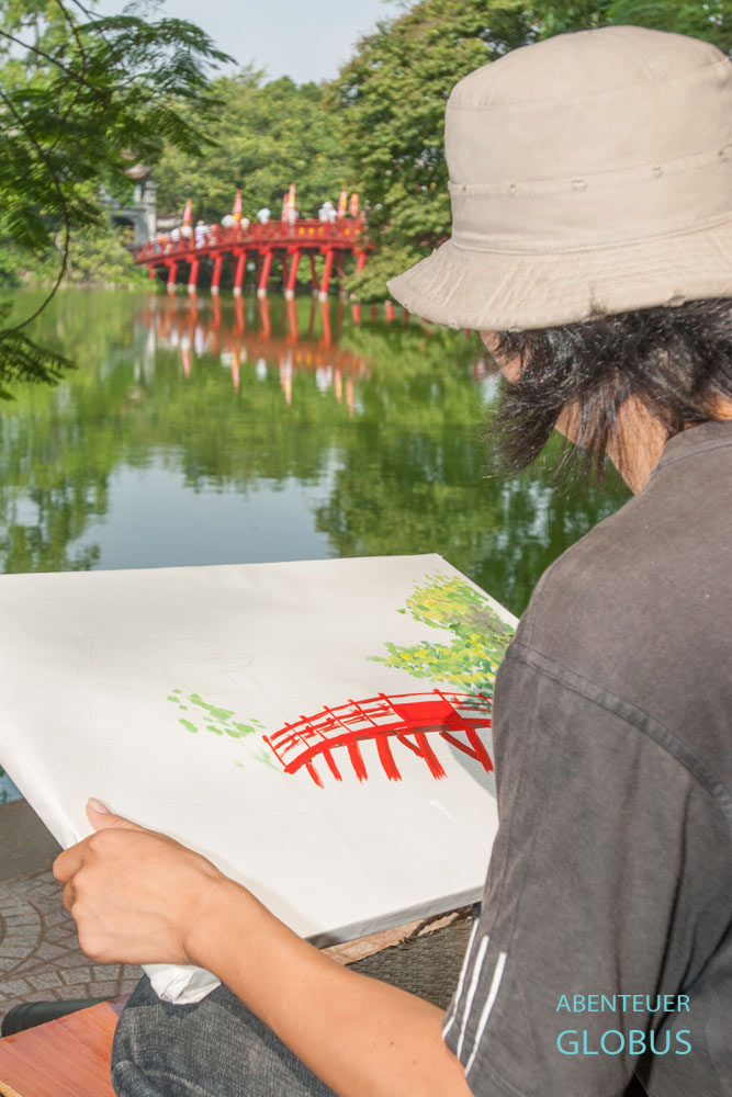 Kunststudent malt die Holzbrücke The Huc am Hoan Kiem See in Hanoi