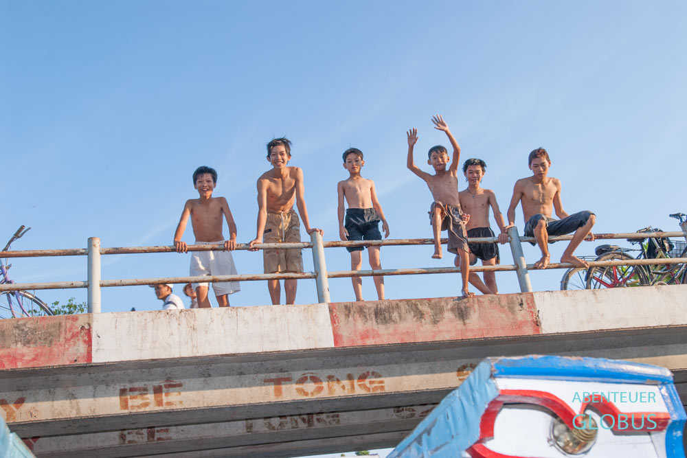 Während der Bootstour im Mekong-Delta: Winkende Jungen auf einer Brücke