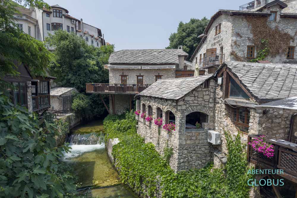 Altstadt von Mostar (Westteil): Blick von der Krummen Brücke (Crooked Bridge) auf den Fluss Radobolja und die restaurierten Häuser