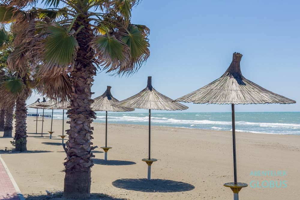 Sonnenschirme und Palmen am Spille Beach