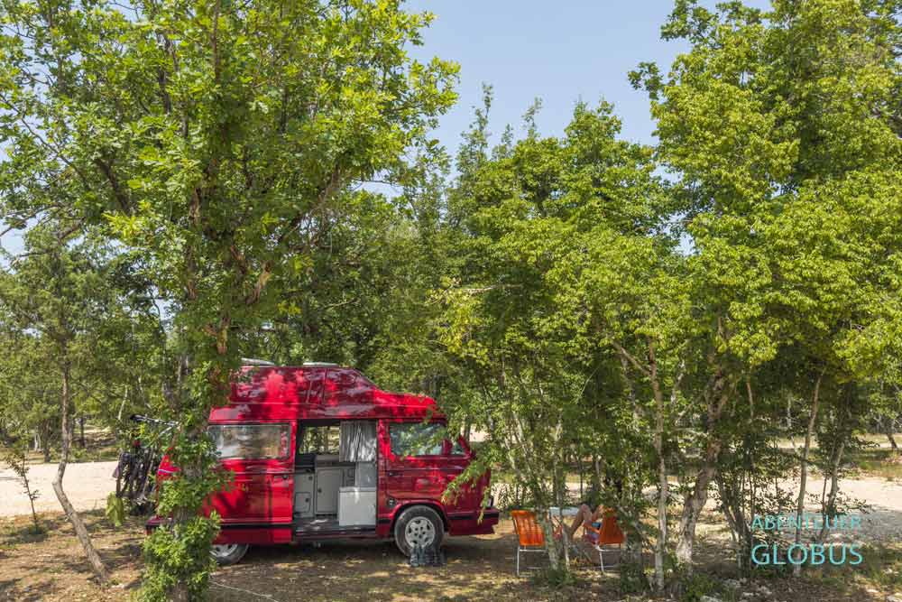 Wohnmobil auf einem schattigen Stellplatz im Auto Camp Ante Kravica, Bosnien und Herzegowina.