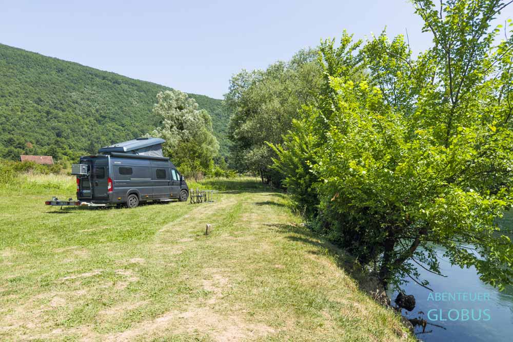 Grauer Kastenwagen am Fluss Una auf dem Campingplatz Status Quo in Kulen Vakuf, Bosnien und Herzegowina.