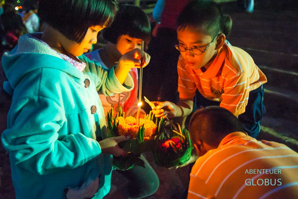 Kinder bereiten ihren Krathong vor, um ihn ins Wasser zu lassen.