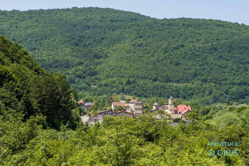 Martin Brod mit Kloster Rmanj zwischen grünen Bergen