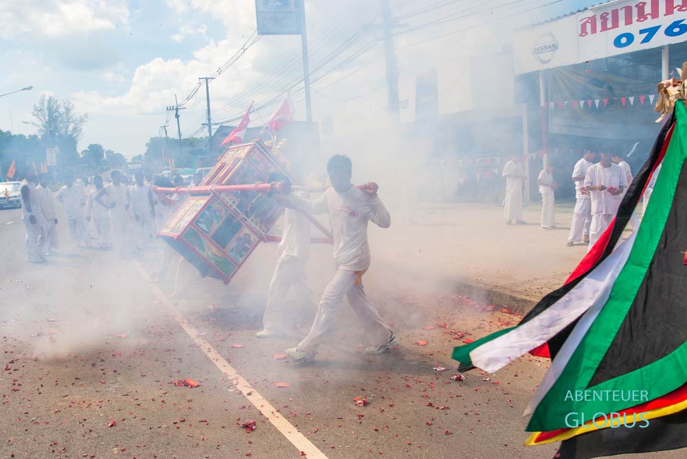 Dichter Rauch der Böller hüllt die Straßen von Phuket ein.