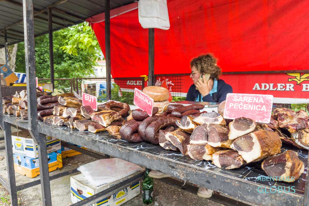 Wochenmarkt vor dem Supermarkt Bingo in Jajce: Angebot von Schinken und Wurst