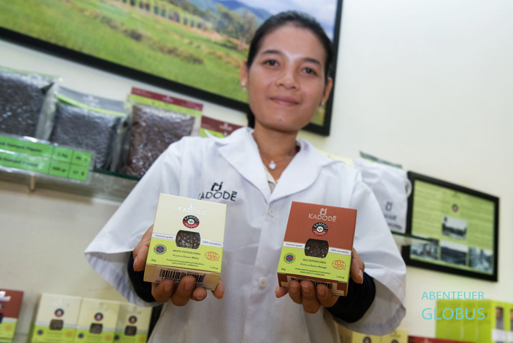 Qualitätsprüferin zeigt Päckchen mit Kampot-Pfeffer, der bei Farmlink Ltd. Kadode verkauft wird.