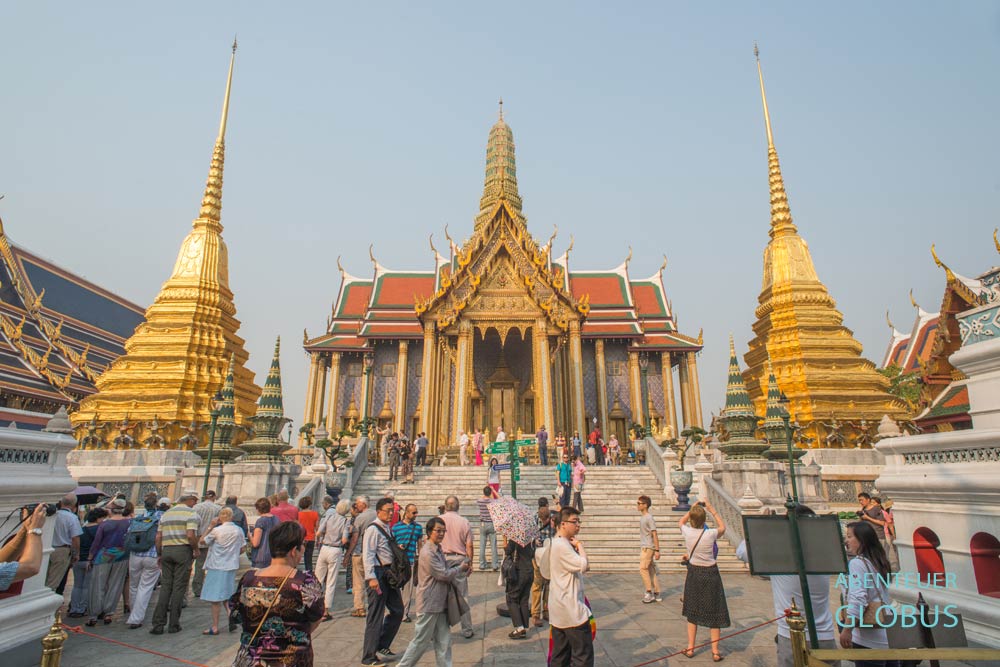 Der Wat Phra Kaeo in Bangkok mit Besuchern im Vordergrund.