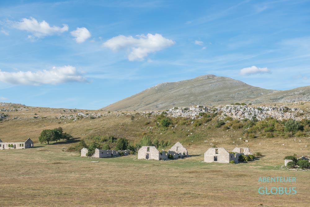 Karstplateau Kruzi: Häuser der Alten Molkerei Livno (Mjekara Livno) und Berg Cincar