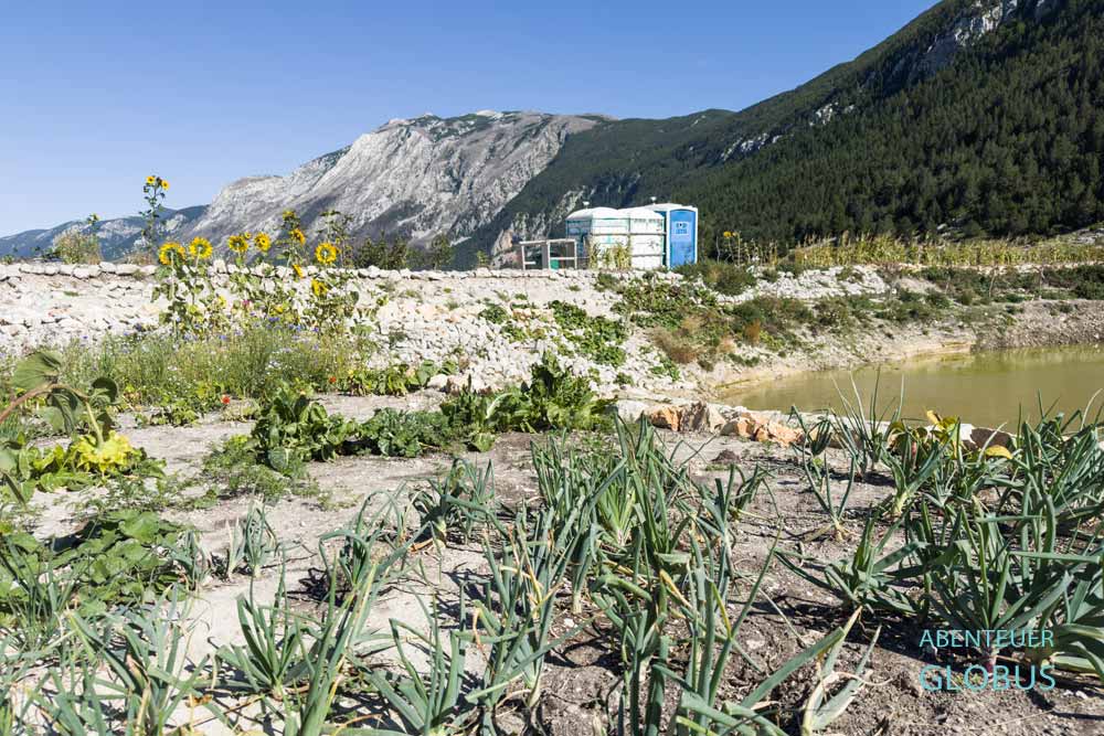 Die Gemüsebeete am Teich und die Sanitäranlagen gehören zum Campingplatz Camp Blidinje am Blidinje-See im Naturpark Blidinje. 