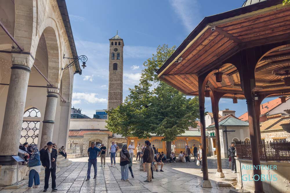 Attraktionen in Sarajevo: Gazi Husrev Beg Moschee, Innenhof mit Waschbrunnen, Uhrturm Sahat Kula im Hintergrund