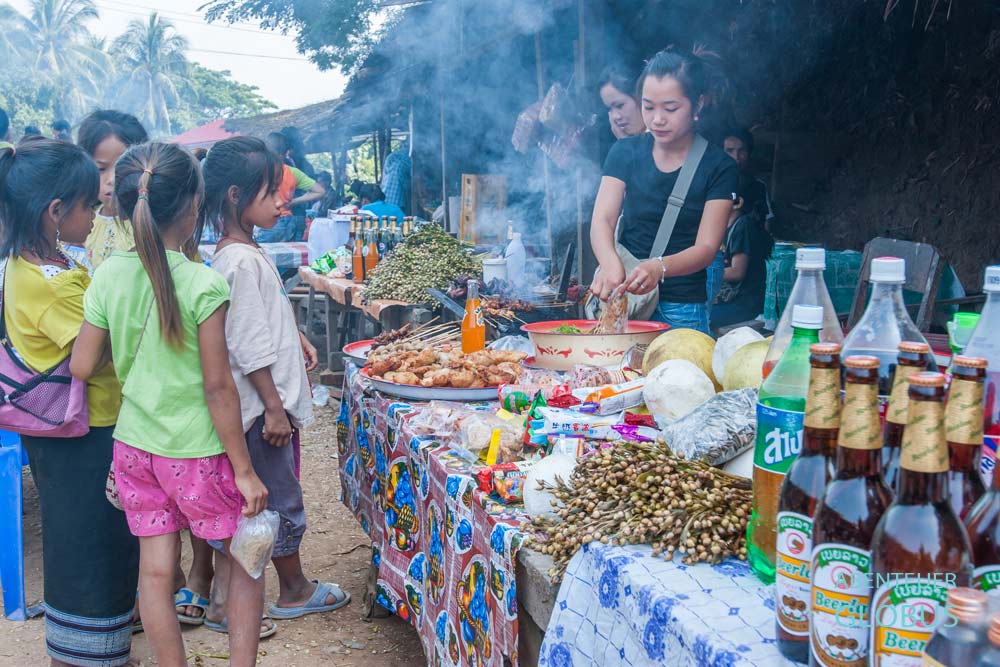 Eine Frau verkauft Fleischspießchen auf dem Morgenmarkt in Ban Sop Jam.