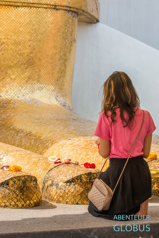 Betende Frau vor der 30 Meter hohen Buddha-Statue im Wat Intharawihan