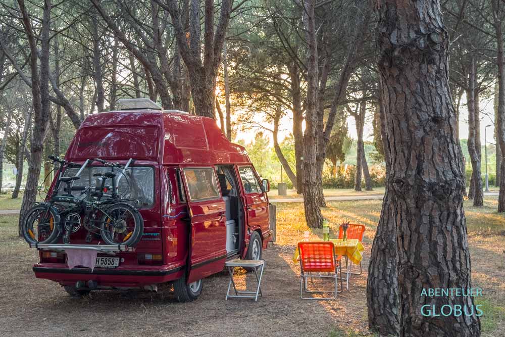 Roter Camper VW T3 unter Kiefern auf dem Campingplatz Camp Vransko Lake Crkvine am Vraner See in Kroatien