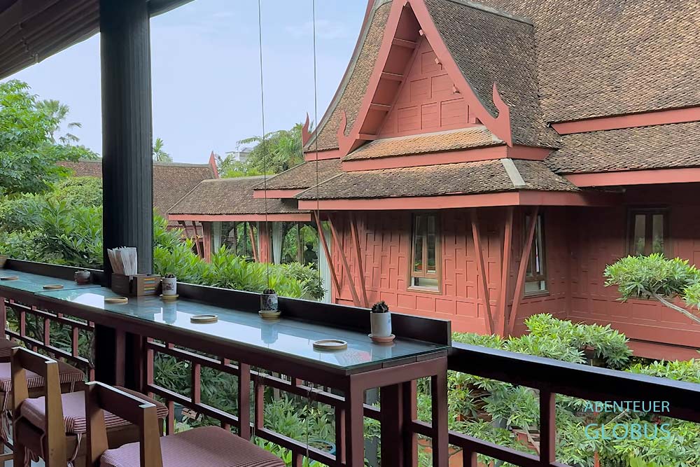 Traditionelle Holzhäuser mit langgezogenen Dächern im Jim Thompson House Museum