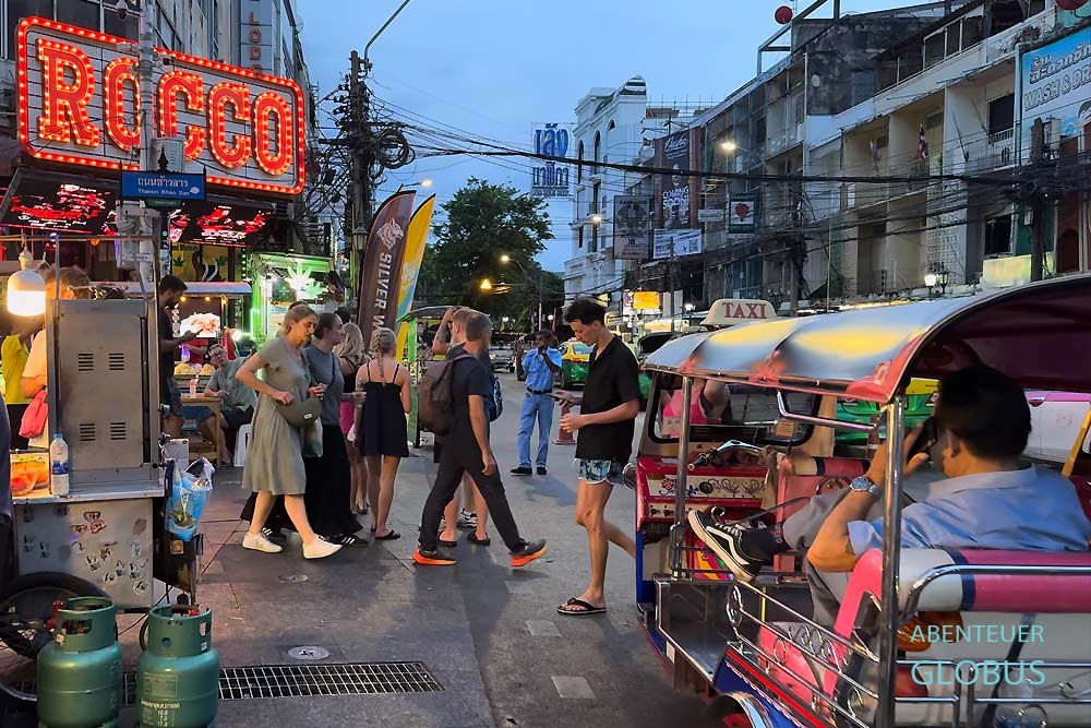 Tuk-Tuk auf der Khao San Road in Bangkok, umgeben von Menschen