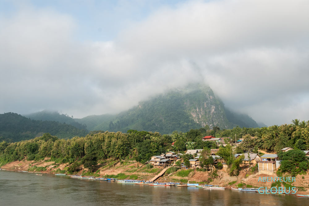 Nong Khiaw am Fluss Nam Ou vor wolkenverhüllten Bergen.