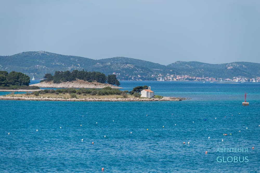 Die Inseln Otočić Babuljaš, Otok Veli Školj und Otočić Sveta Justina mit der Kapelle St. Justina, im Hintergrund die Insel Pašman