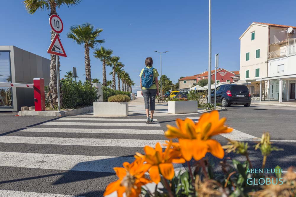 Urlauberin bummelt auf der Uferpromenade in Sveti Filip i Jakov. 