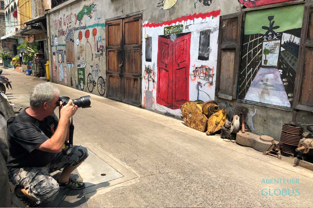 Ein Fotograf macht ein Bild von einer Graffiti-Wand im Stadtteil Talat Noi, Bangkok.