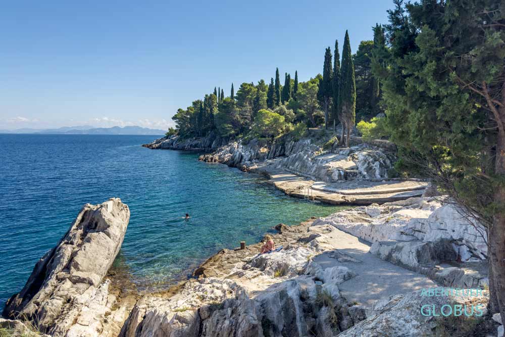 Dracevac Beach unterhalb der Promenade am Meer mit Steinplattformen und Felsen in Trpanj