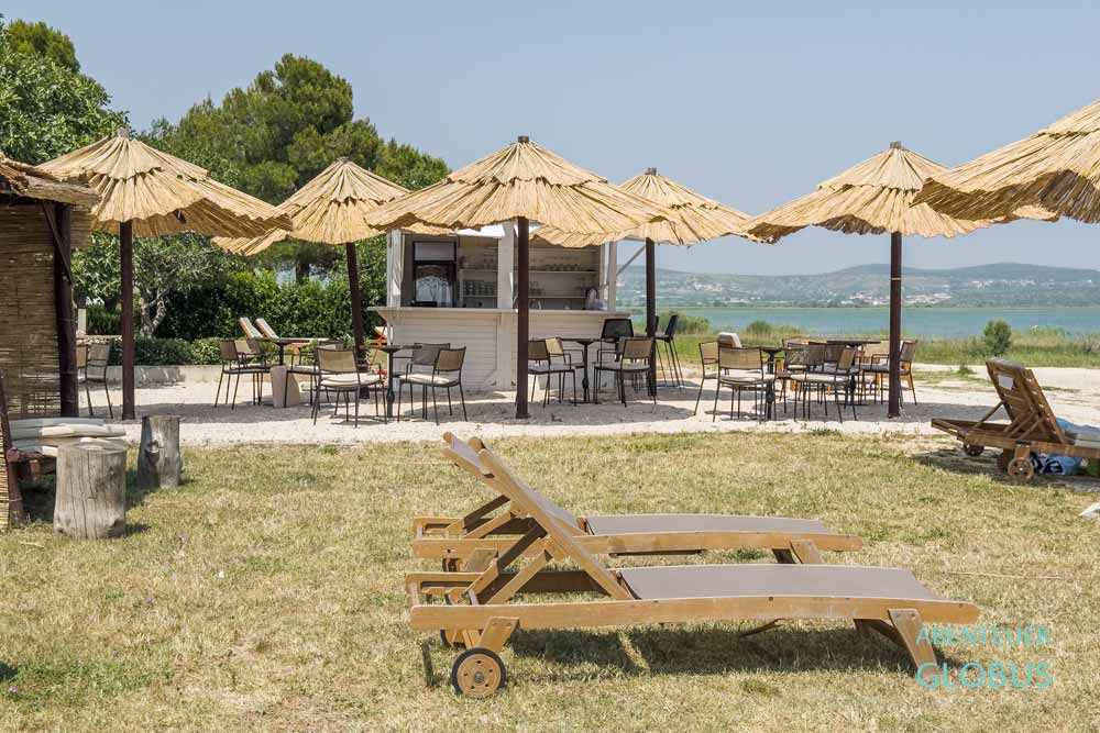 Beachbar, Liegen und Sonnenschirme vom Campingplatz Camp Vransko Lake Crkvine am Vraner See in Kroatien