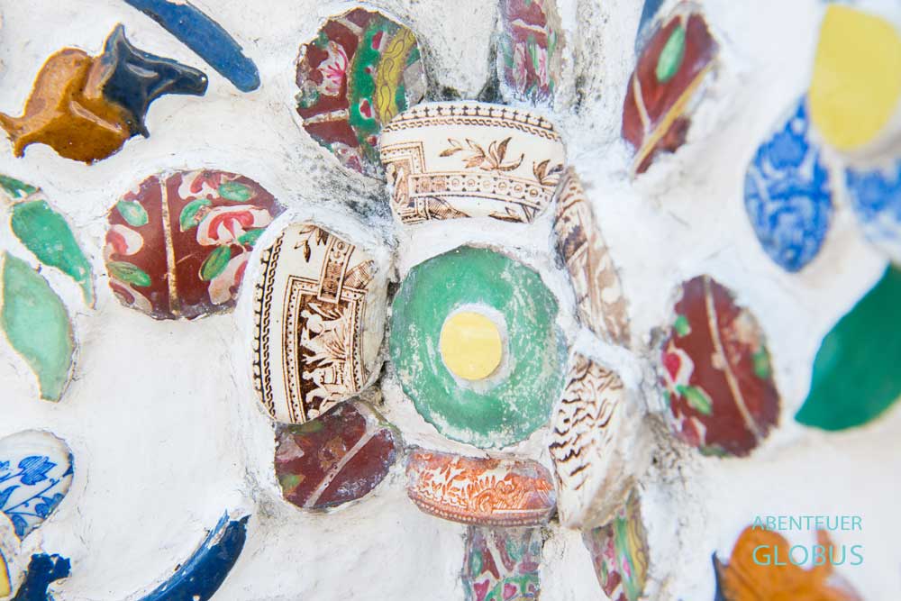 Detailaufnahme farbenfroher Keramik- und Glasverzierungen am Wat Arun in Bangkok