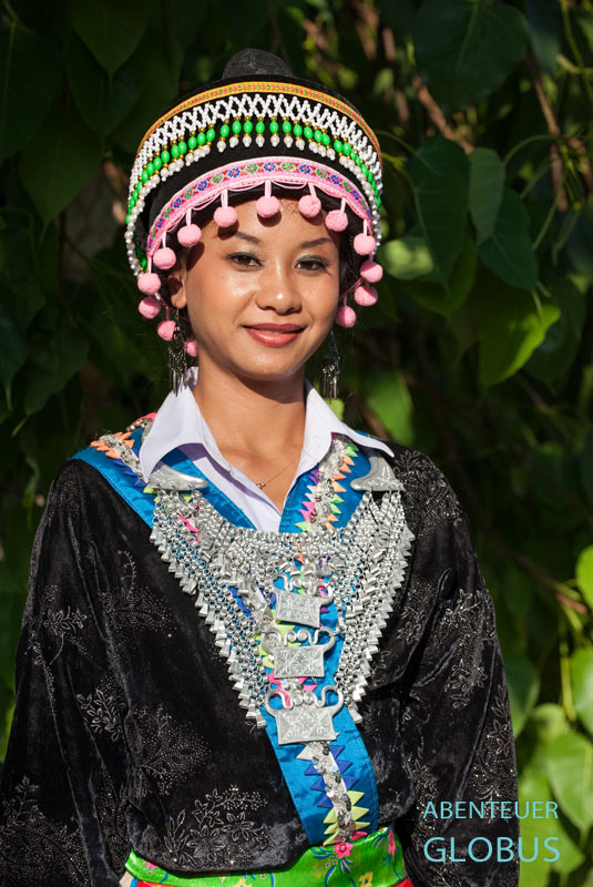 Hmong-Frau in traditioneller Tracht, Kopfbedeckung und Schmuck in Muang Khoun
