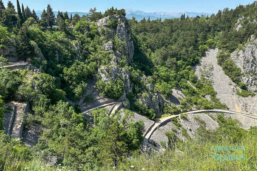 Zickzackweg zwischen Bäumen zum Strand am Blauen See in Imotski