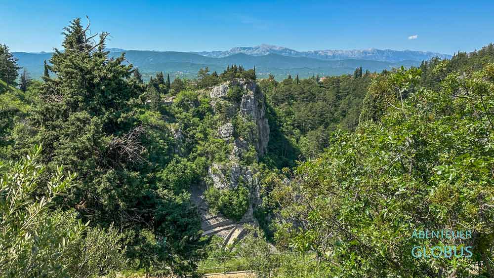 Zickzackweg inmitten der Natur zum Blauen See in Imotski, im Hintergrund das Biokovo-Gebirge