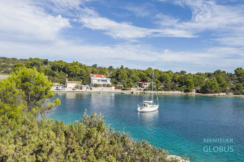 Segelboot in der Bucht Sveti Nikola, im Hintergrund Sveti Nikola Kirche und Apartmenthaus auf der Insel Murter