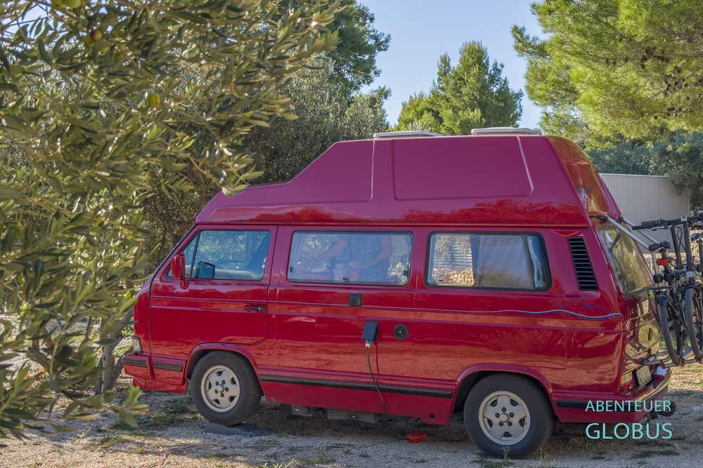 Roter Camper VW T3 an Olivenbäumen auf dem Campingplatz Jezera Lovišća in Jezera auf der Insel Murter