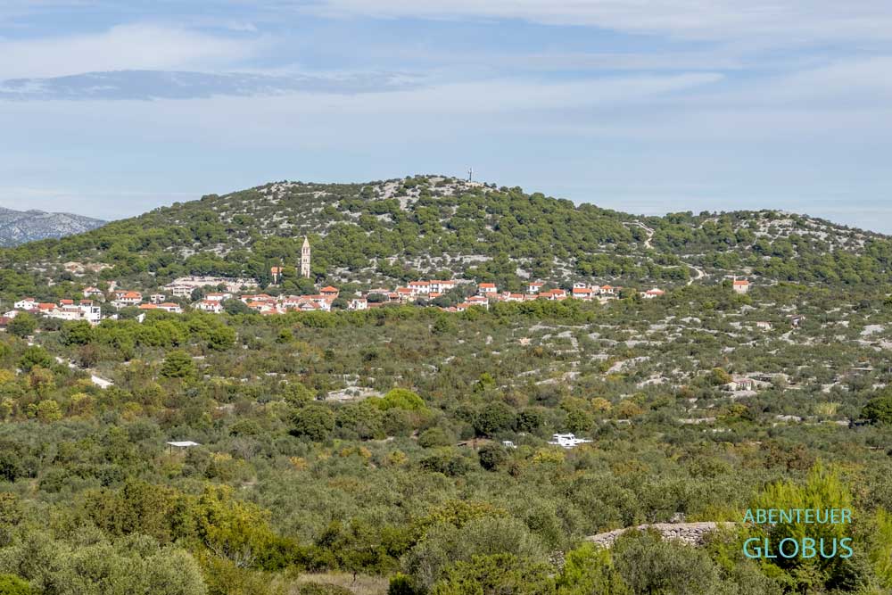 Ort Jezera mit der Kirche Unserer Lieben Frau von der Gesundheit vor einem Hügel auf der Insel Murter