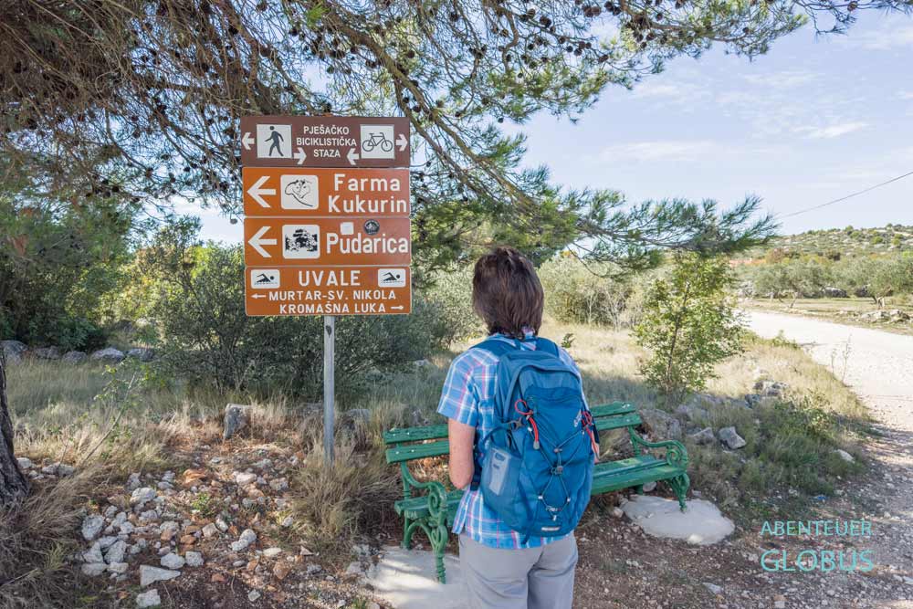 Wanderin vor Wegweiser auf der Insel Murter
