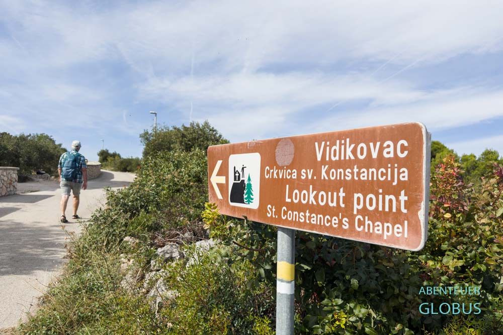Hinweisschild und Wanderer zum Aussichtspunkt an der Kapelle des Heiligen Constantius in Jezera