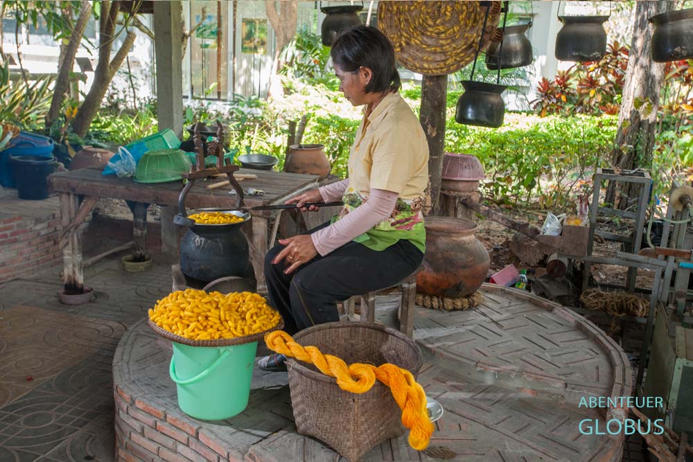 Frau haspelt Seidenfäden von Seidenkokons im Seidenzentrum Mulberries, Phonsavan.