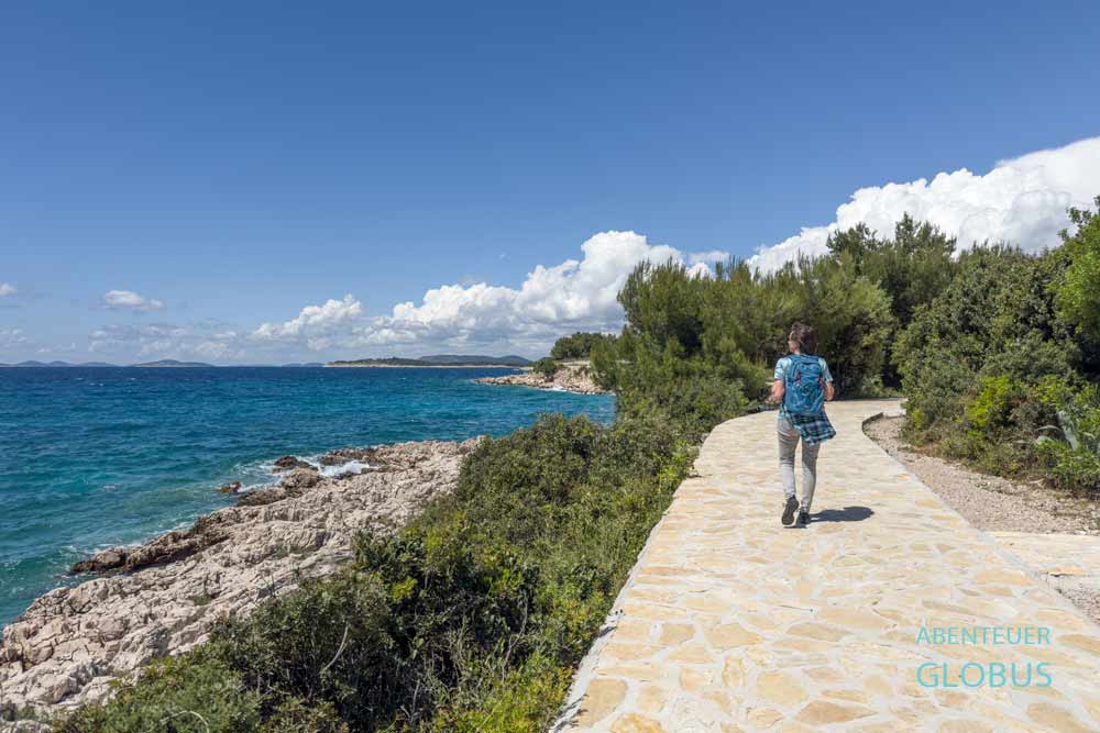 Wanderin auf der Uferpromenade Lungomare Primosten, Kroatien