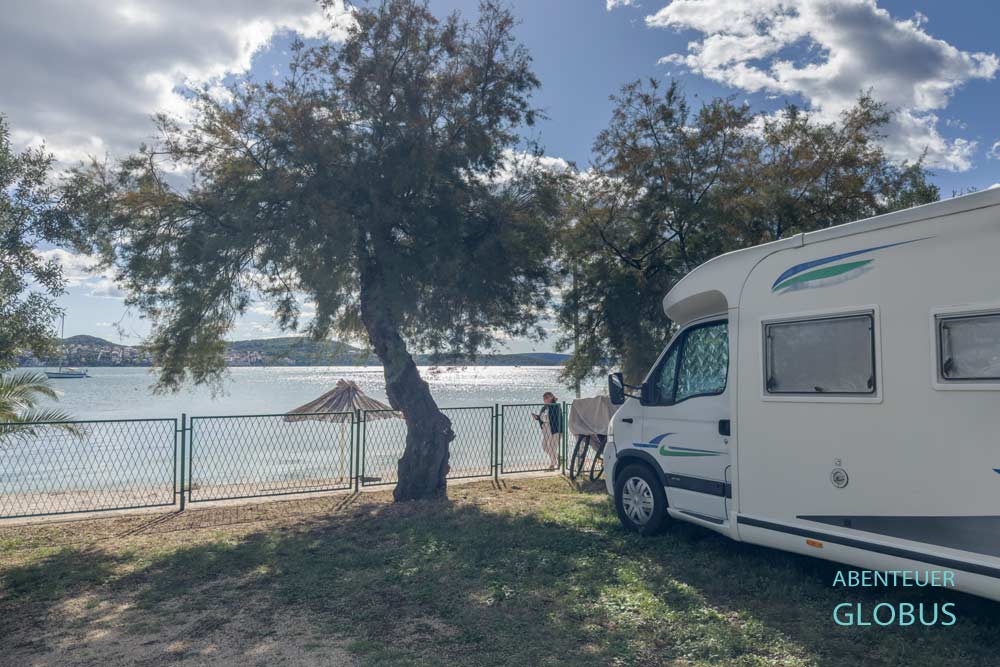 Wohnmobil zwischen Bäumen in der ersten Reihe am Meer auf dem Kamp Seget 