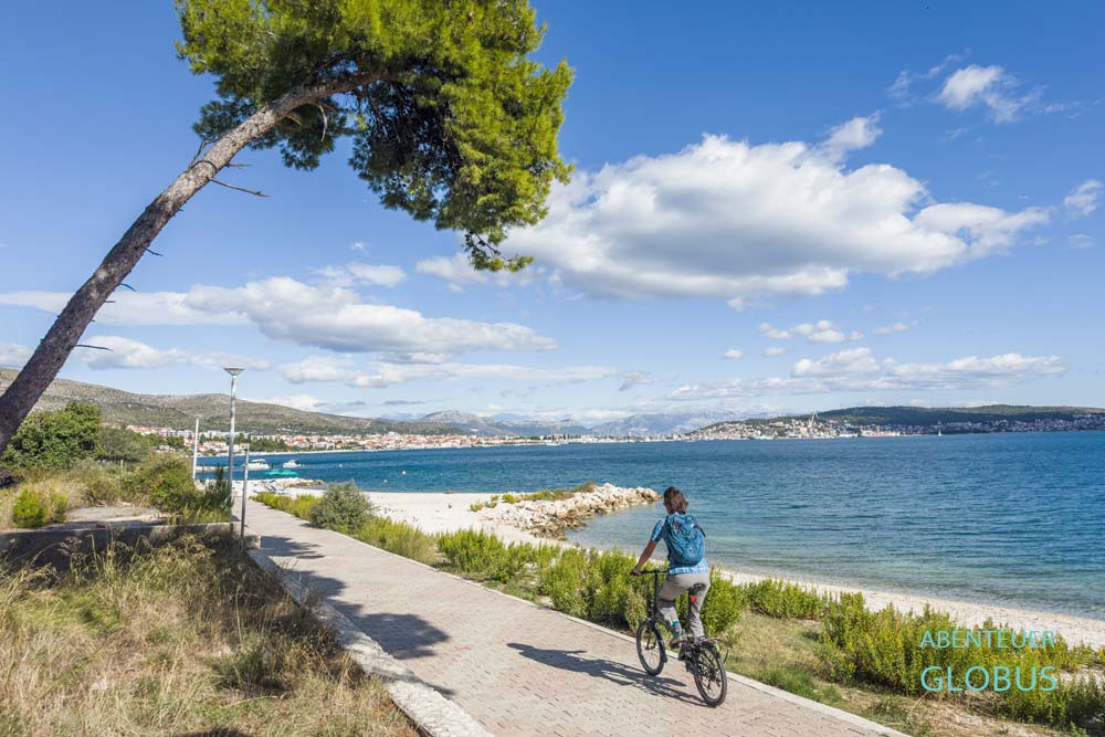 Radfahrerin auf der Uferpromenade zwischen Seget Donji und Strand Medena