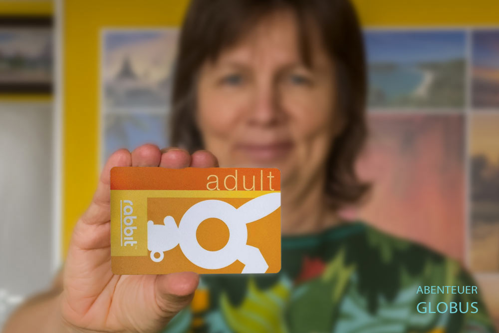 Frau hält eine Rabbit Card (Adult) für den BTS Skytrain Bangkok in die Kamera