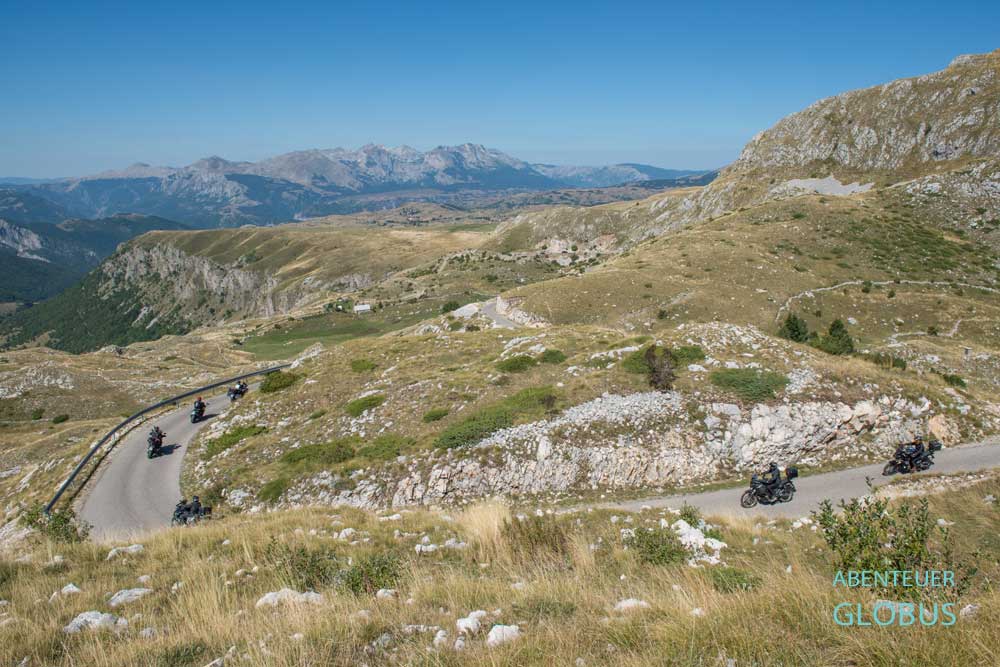 Haarnadelkurve mit Motorradfahrern auf der Panoramastraße Durmitor-Ring und das Tal Pirni Do (links im Bild) im Naturpark Piva