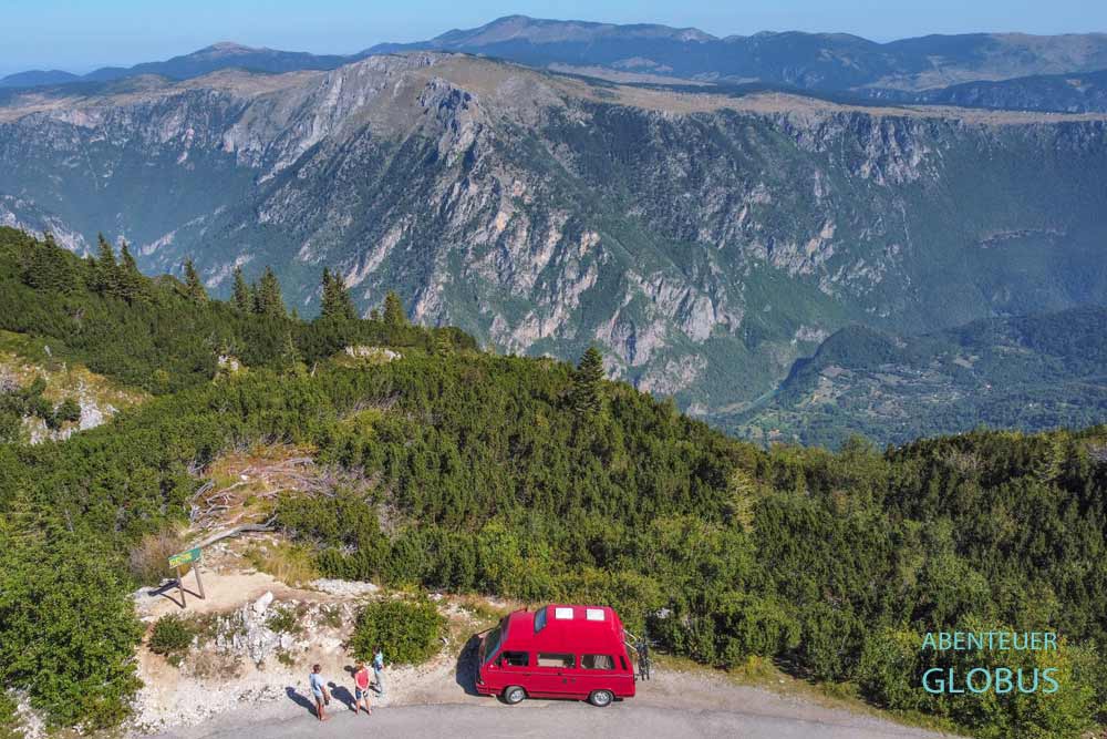Roter Camper und drei Touristen am Aussichtspunkt Veliki Stuoc (Viewpoint Tara Canyon) am Durmitor-Ring im Durmitor-Nationalpark