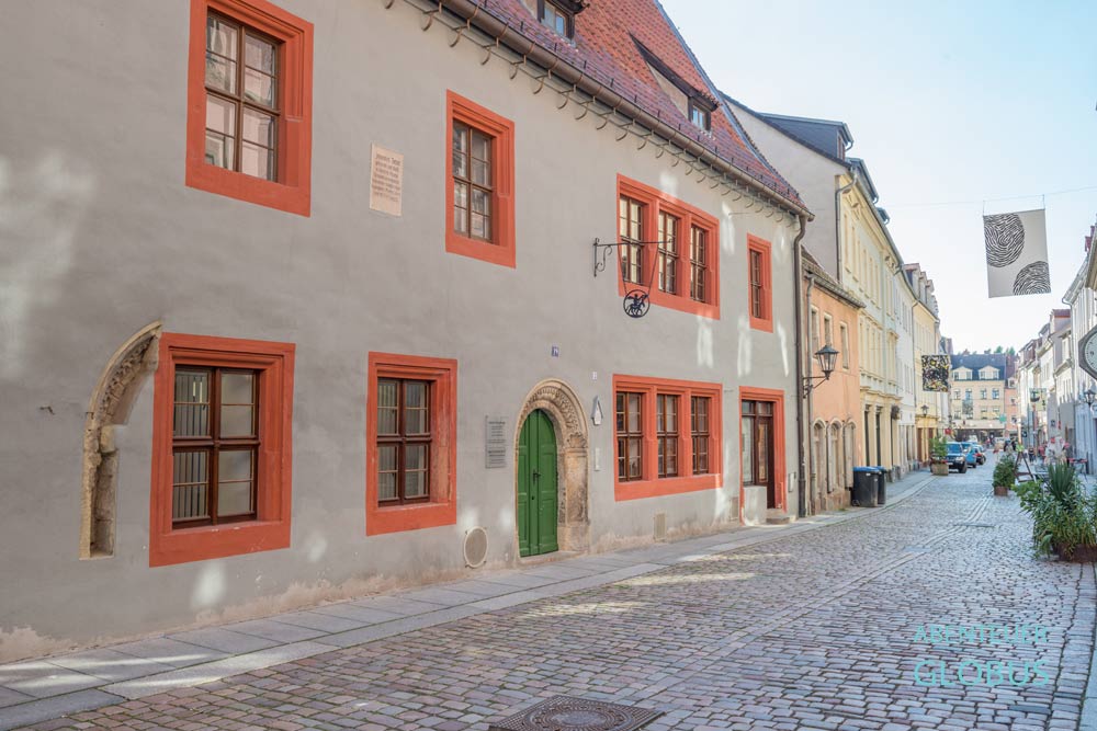 Tetzel-Haus mit orangfarbenen Fensterumrandungen in einer Altstadtgasse in Pirna, Sachsen