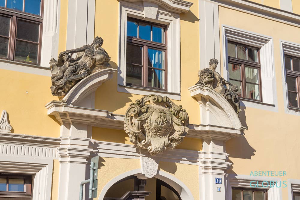 Barockes Portal mit Figuren und Wappen an einem Bürgerhaus in Pirna
