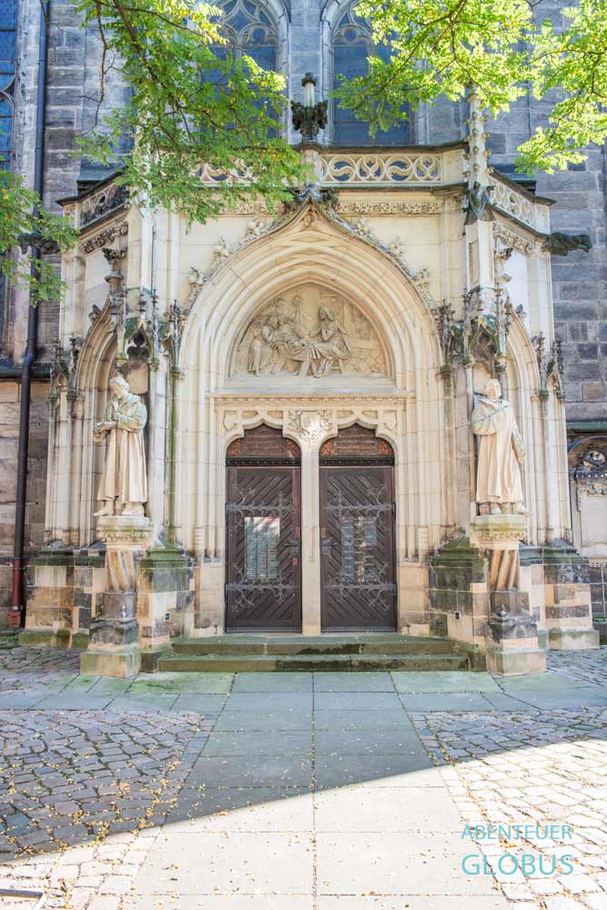 Detailansicht des reich verzierten Sandsteinportals mit Figuren an der Stadtkirche St. Marien in Pirna