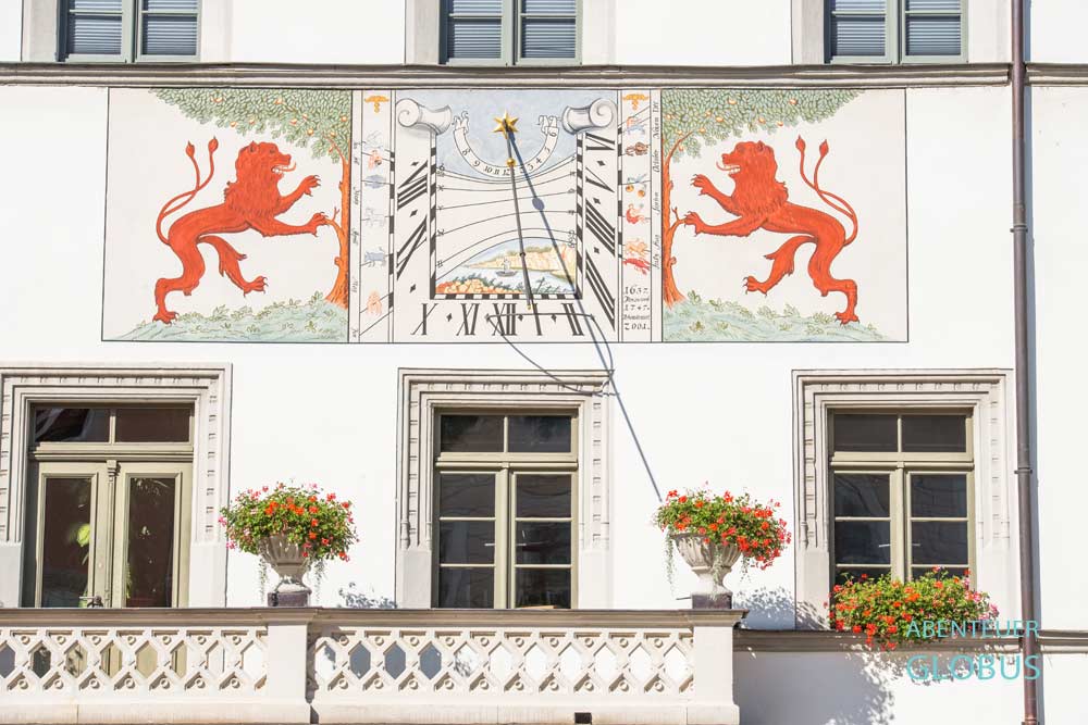 Sonnenuhr, flankiert von zwei roten Löwen am Rathaus von Pirna