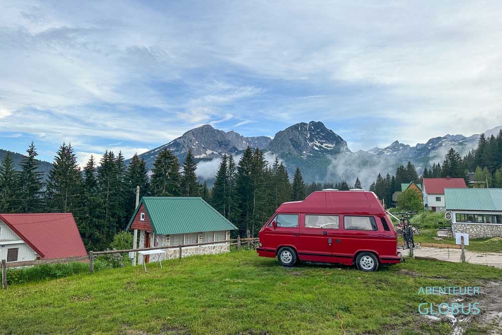 Roter Bulli VW T3 auf dem Auto Camp Mlinski Potok in Zabljak, dahinter das Durmitormassiv mit Berg Bobotov Kuk