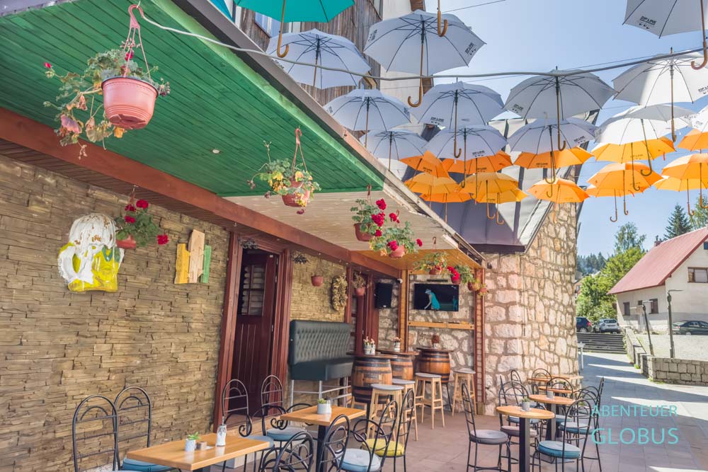 Restaurant Pub Kino Durmitor mit aufgehängten Schirmen am Eingang, in Zabljak